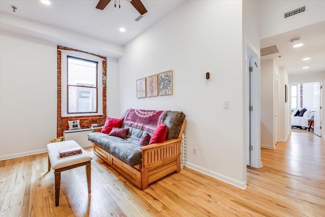 living area featuring light hardwood / wood-style flooring and ceiling fan