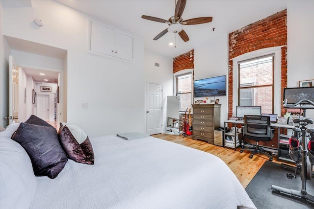 bedroom featuring hardwood / wood-style floors and a towering ceiling