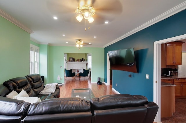 living room with light wood-type flooring, a healthy amount of sunlight, and crown molding