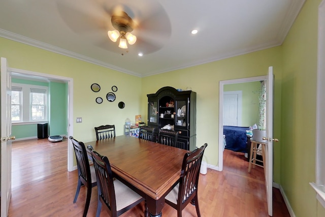 dining space featuring wood-type flooring, ceiling fan, and crown molding