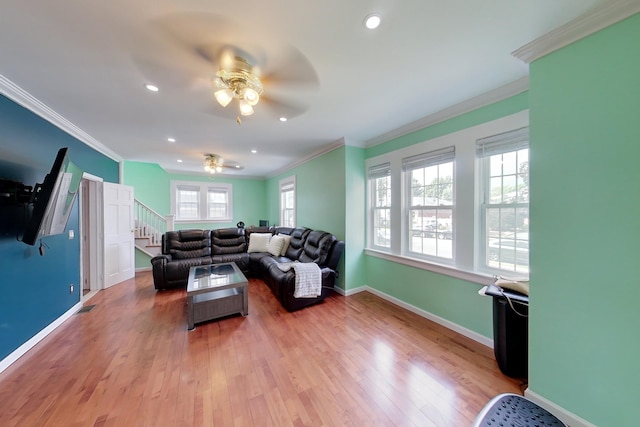 living room with ceiling fan, wood-type flooring, and a healthy amount of sunlight