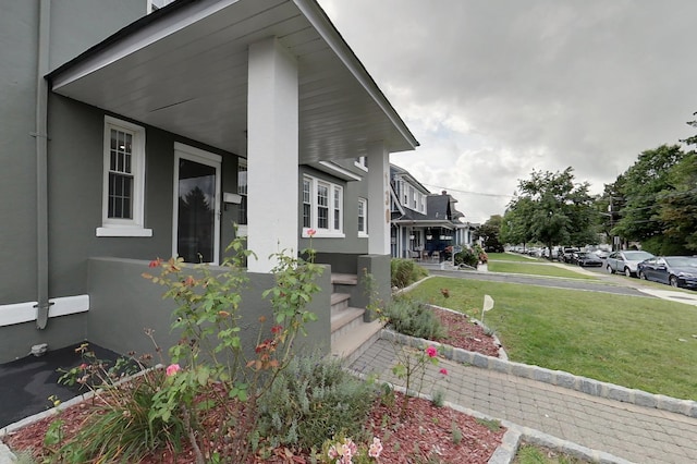 view of home's exterior featuring a lawn and covered porch