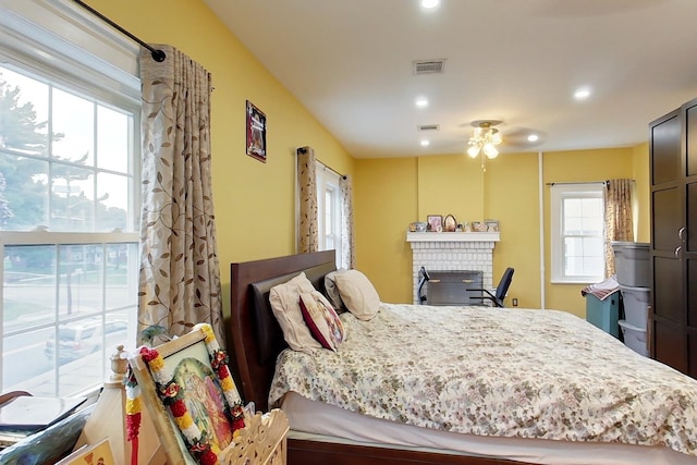 bedroom featuring a brick fireplace and ceiling fan