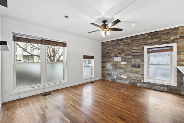 unfurnished room with ceiling fan, wood-type flooring, ornamental molding, and a wealth of natural light