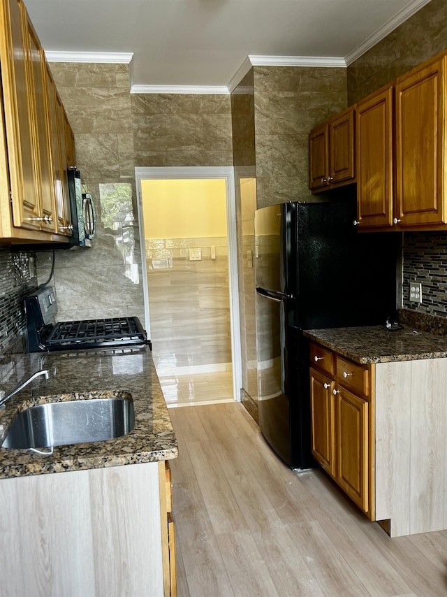 108 Palisade Ave Unit A5, Jersey City, NJ 07306 - kitchen with stainless steel gas range oven, ornamental molding, freestanding refrigerator, light wood finished floors, and dark stone countertops