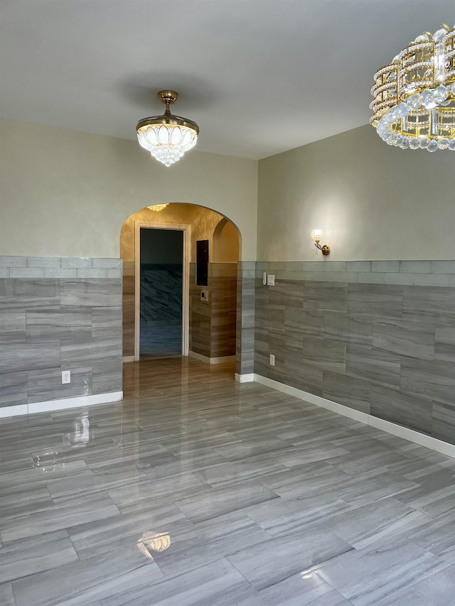 108 Palisade Ave Unit A5, Jersey City, NJ 07306 - unfurnished room with tile walls, arched walkways, a chandelier, and a wainscoted wall