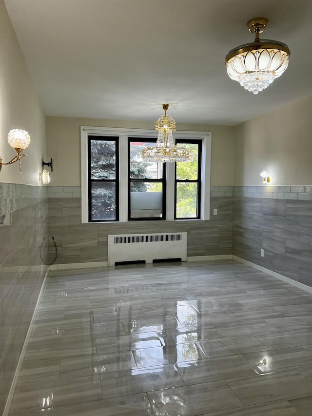 108 Palisade Ave Unit A5, Jersey City, NJ 07306 - unfurnished dining area featuring a chandelier, radiator, tile walls, and wainscoting