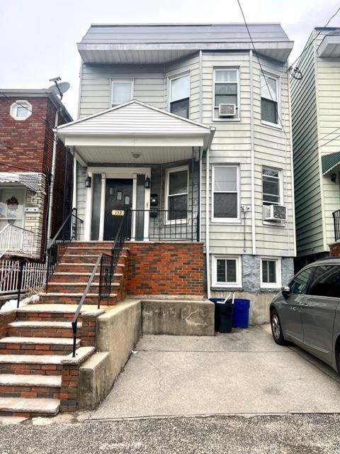 view of front of property with a porch and cooling unit