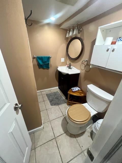 bathroom featuring vanity, tile patterned flooring, toilet, and baseboards