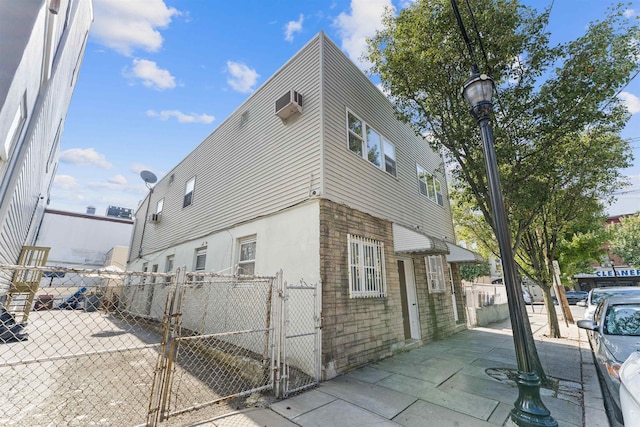 view of home's exterior with a wall mounted AC