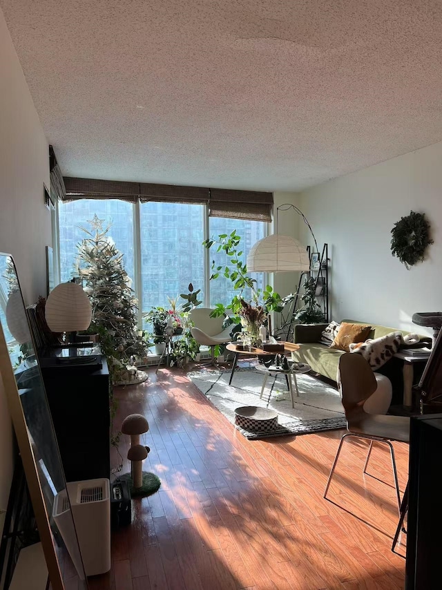 living room featuring a healthy amount of sunlight, wood-type flooring, and a textured ceiling