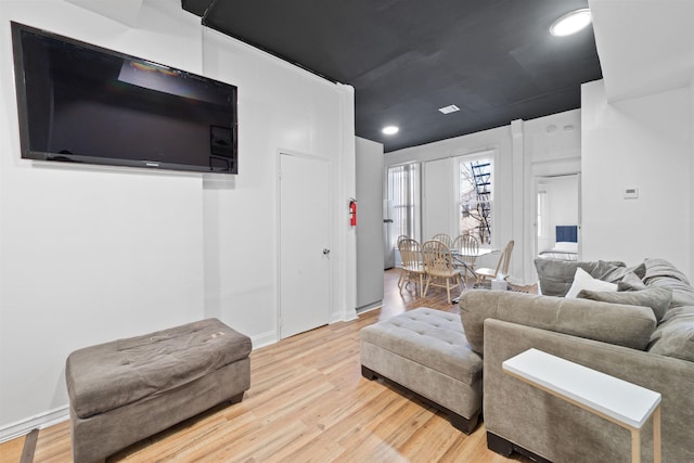 living area featuring light wood-style flooring and recessed lighting