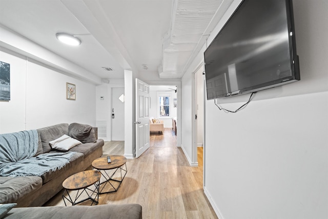 living room with baseboards, visible vents, and light wood-style floors