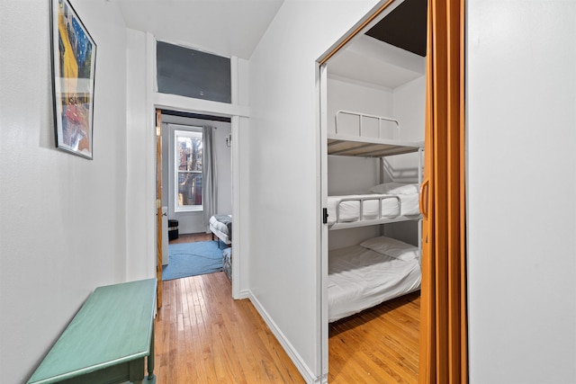 corridor with light wood-style floors and baseboards