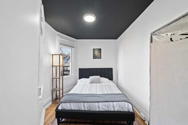 bedroom featuring baseboards and wood finished floors