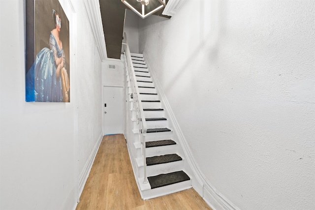 staircase with baseboards and wood finished floors