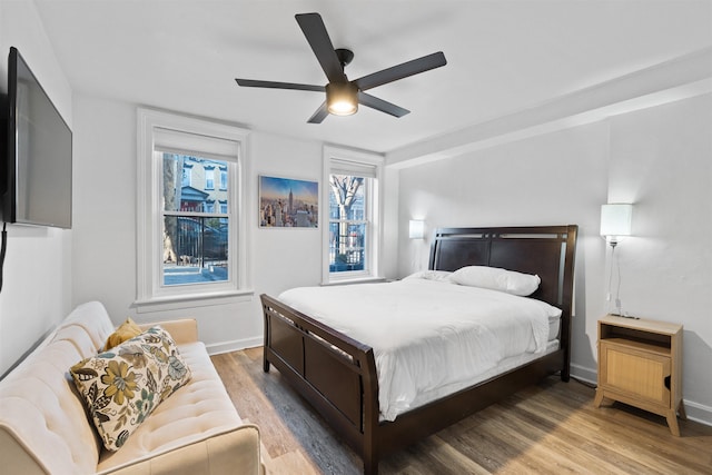 bedroom featuring ceiling fan, wood finished floors, and baseboards