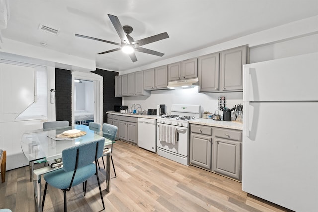 kitchen with white appliances, visible vents, light wood-style floors, gray cabinetry, and under cabinet range hood