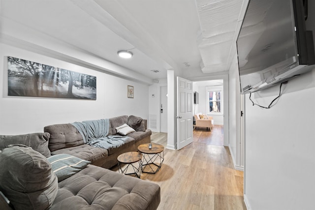 living room with baseboards, visible vents, and light wood finished floors