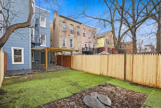 view of yard featuring a fenced backyard, a residential view, and a patio