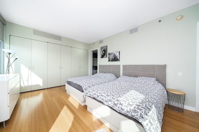 bedroom with light hardwood / wood-style floors and a closet