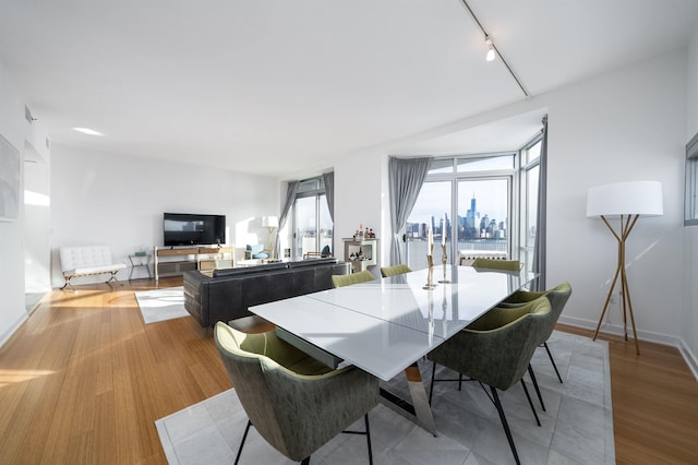 dining room featuring track lighting and light hardwood / wood-style flooring