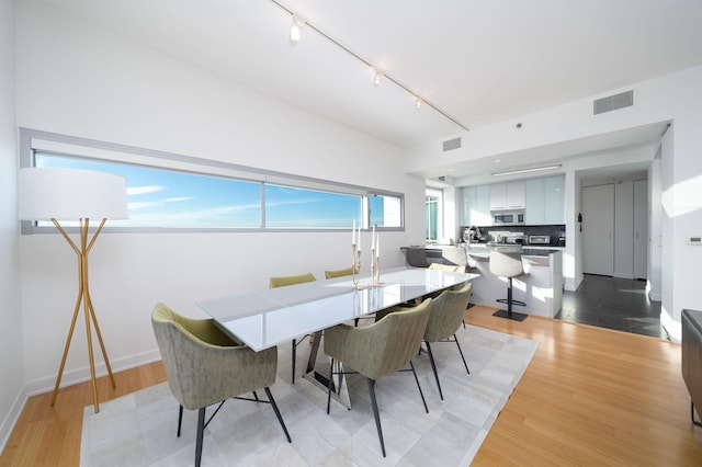 dining room featuring light hardwood / wood-style flooring and rail lighting