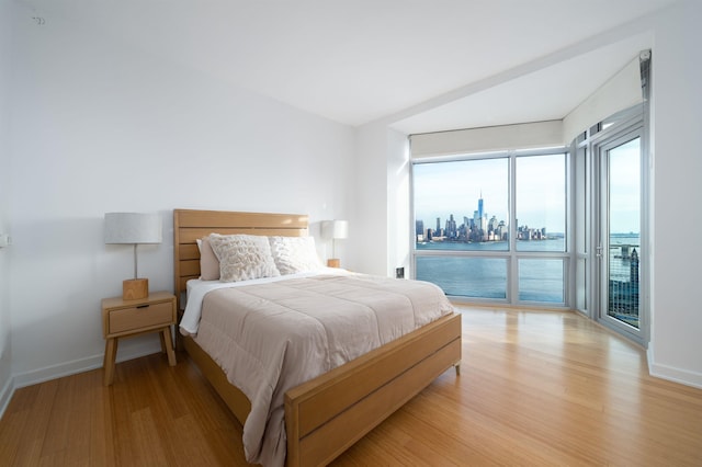 bedroom with access to exterior and light wood-type flooring