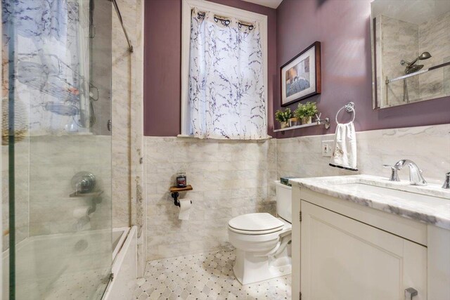 351 5th St Unit 3, Jersey City, NJ 07302 - full bathroom featuring tile walls, vanity, combined bath / shower with glass door, and a wainscoted wall