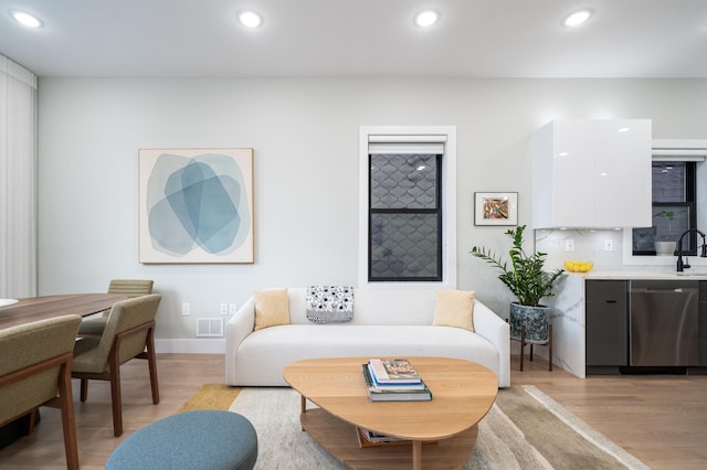 living room featuring light hardwood / wood-style flooring and sink