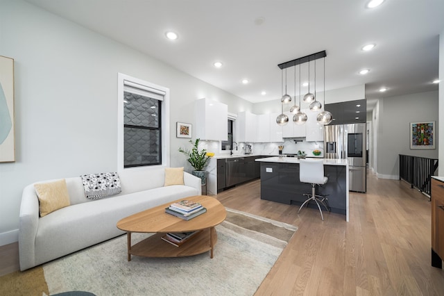 living room with light hardwood / wood-style flooring and sink