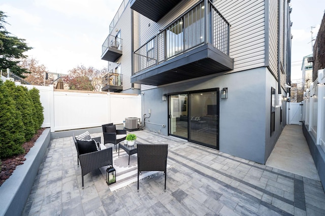 view of patio / terrace with outdoor lounge area, a balcony, and central AC