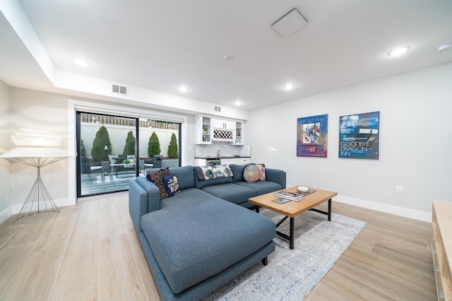 living room featuring bar area and light wood-type flooring