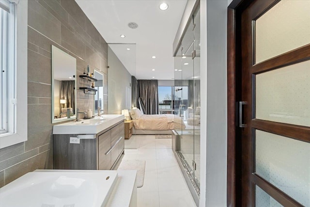 bathroom with tile patterned floors, ensuite bathroom, recessed lighting, tile walls, and vanity