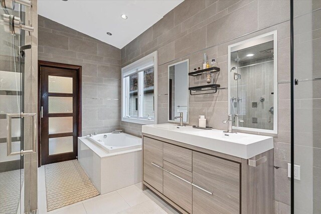 bathroom with a garden tub, lofted ceiling, a stall shower, tile walls, and tile patterned floors