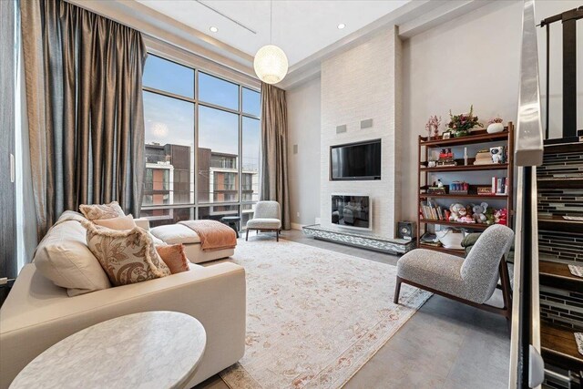 living area with recessed lighting, a fireplace, and a towering ceiling