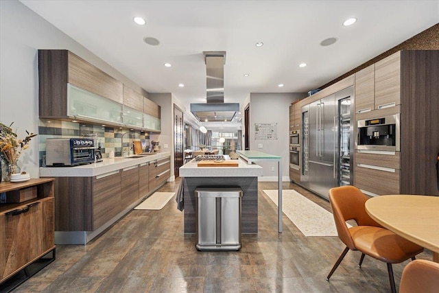 kitchen featuring a kitchen island, light countertops, decorative backsplash, island range hood, and modern cabinets