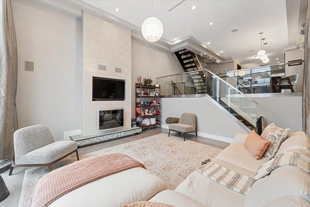 living room featuring stairway, recessed lighting, and a fireplace