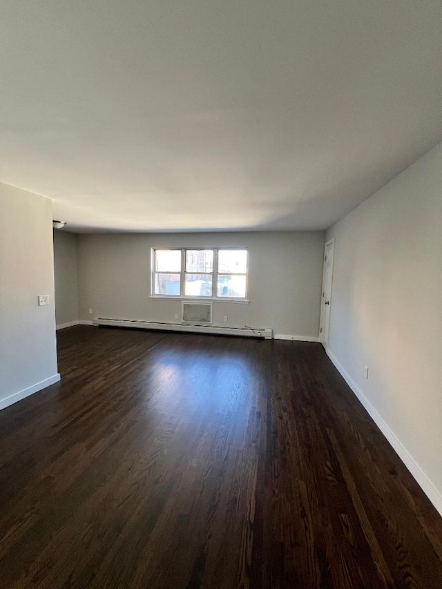 empty room with a baseboard radiator and dark hardwood / wood-style floors