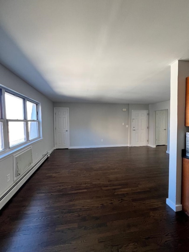 unfurnished room featuring dark hardwood / wood-style flooring and a baseboard heating unit