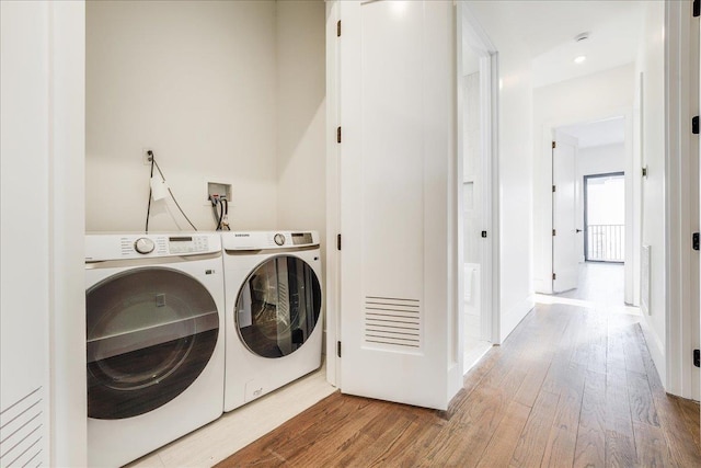 laundry area with washing machine and dryer and hardwood / wood-style floors