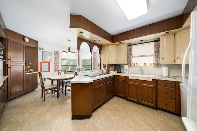 166 W 37th St, Bayonne, NJ 07086 - kitchen with a peninsula, light countertops, a chandelier, and white appliances