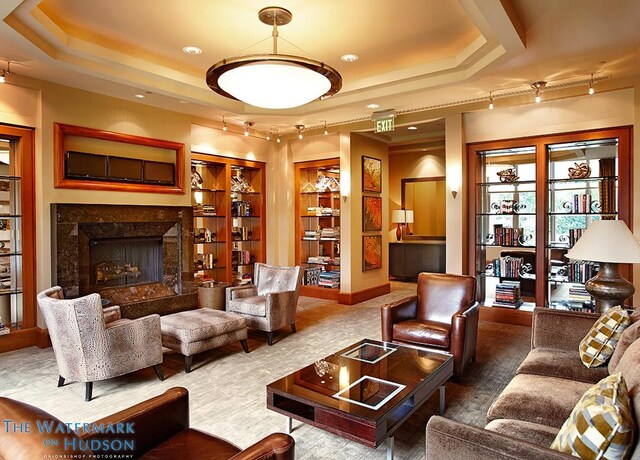 8100 River Rd Unit 0107, North Bergen, NJ 07047 - living area with a tray ceiling, a fireplace, built in shelves, and track lighting