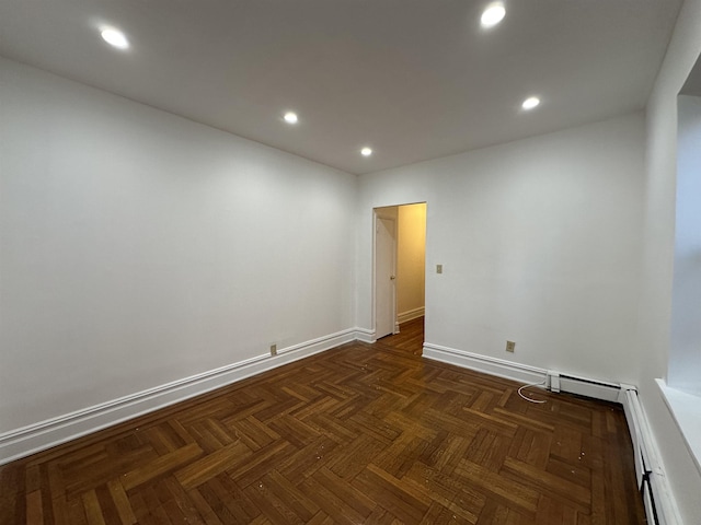 spare room featuring dark parquet flooring