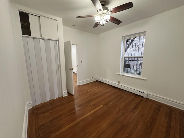 unfurnished bedroom featuring a closet, ceiling fan, a baseboard heating unit, and dark hardwood / wood-style floors