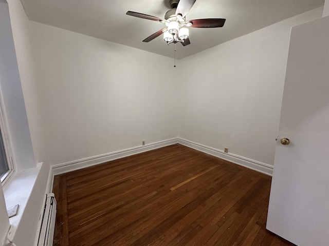 empty room with dark hardwood / wood-style floors, ceiling fan, and a baseboard radiator