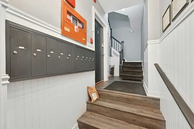 stairs with hardwood / wood-style flooring and a mail area