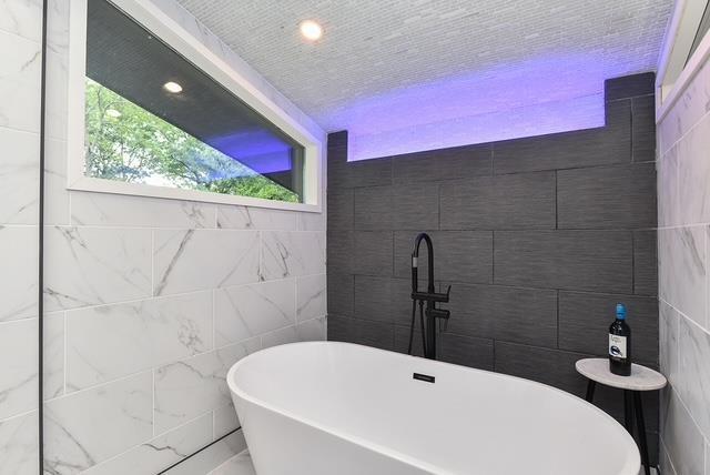 203 Stanhope Rd, Sparta, NJ 07871 - bathroom featuring tile walls, a freestanding bath, and recessed lighting