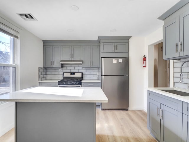 kitchen with visible vents, appliances with stainless steel finishes, a sink, and gray cabinetry