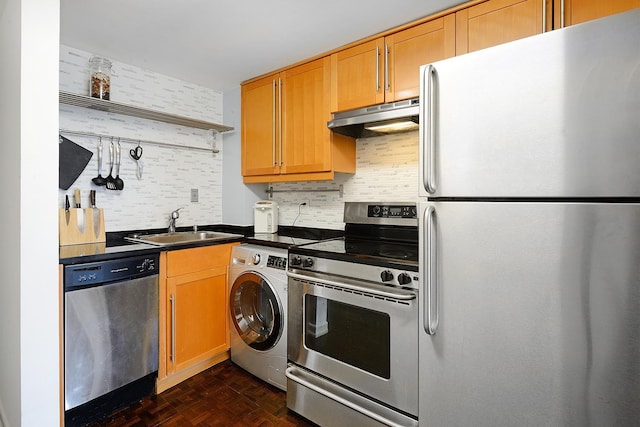 212 9th St Unit 4B, Jersey City, NJ 07302 - kitchen with appliances with stainless steel finishes, under cabinet range hood, washer / clothes dryer, dark countertops, and backsplash